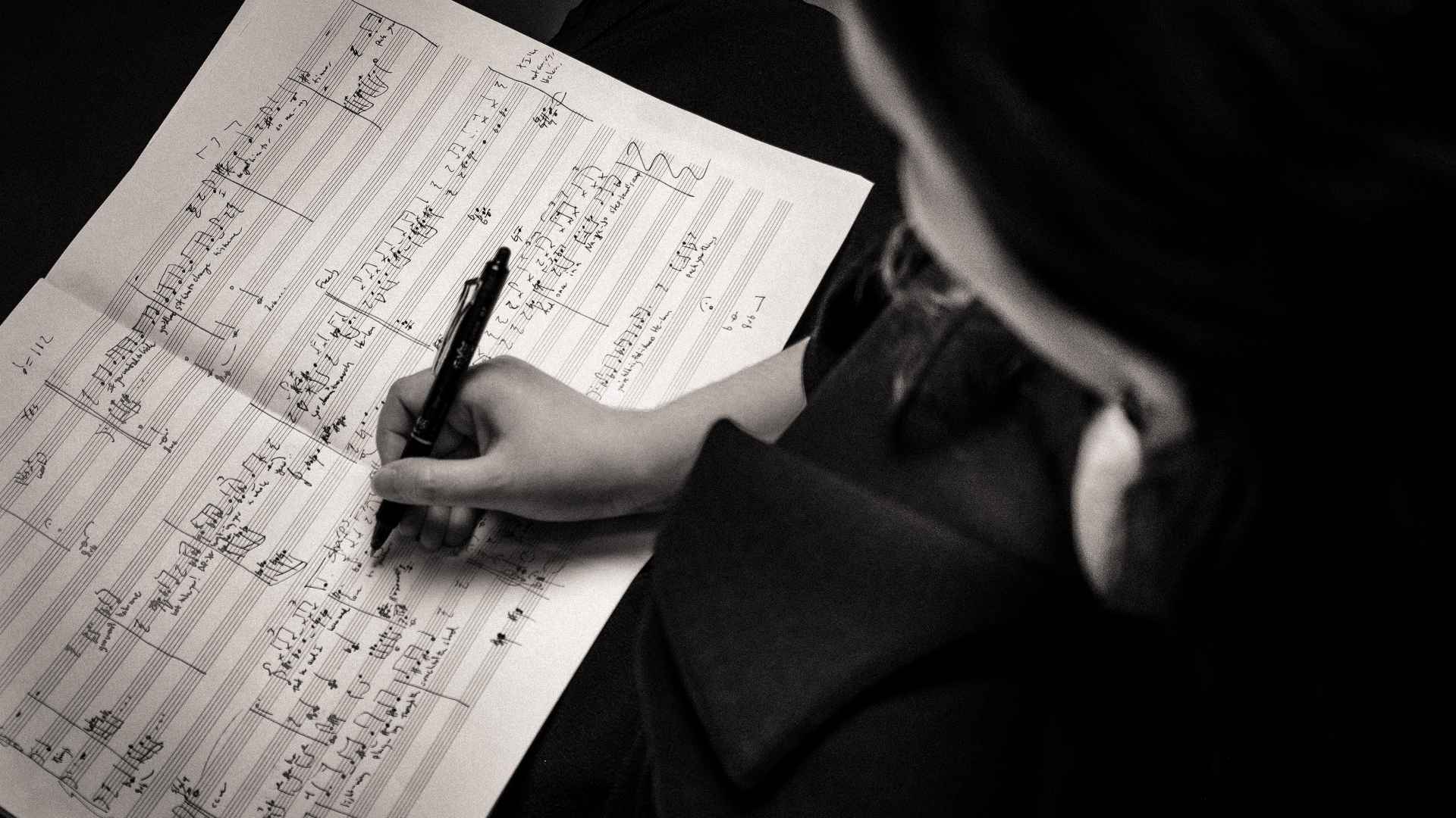 Abstract photograph of Jessica Hunt's hand as she writes music notation